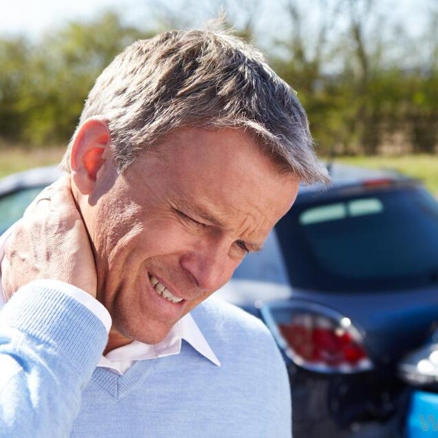 man-rubbing-neck-after-car-wreck